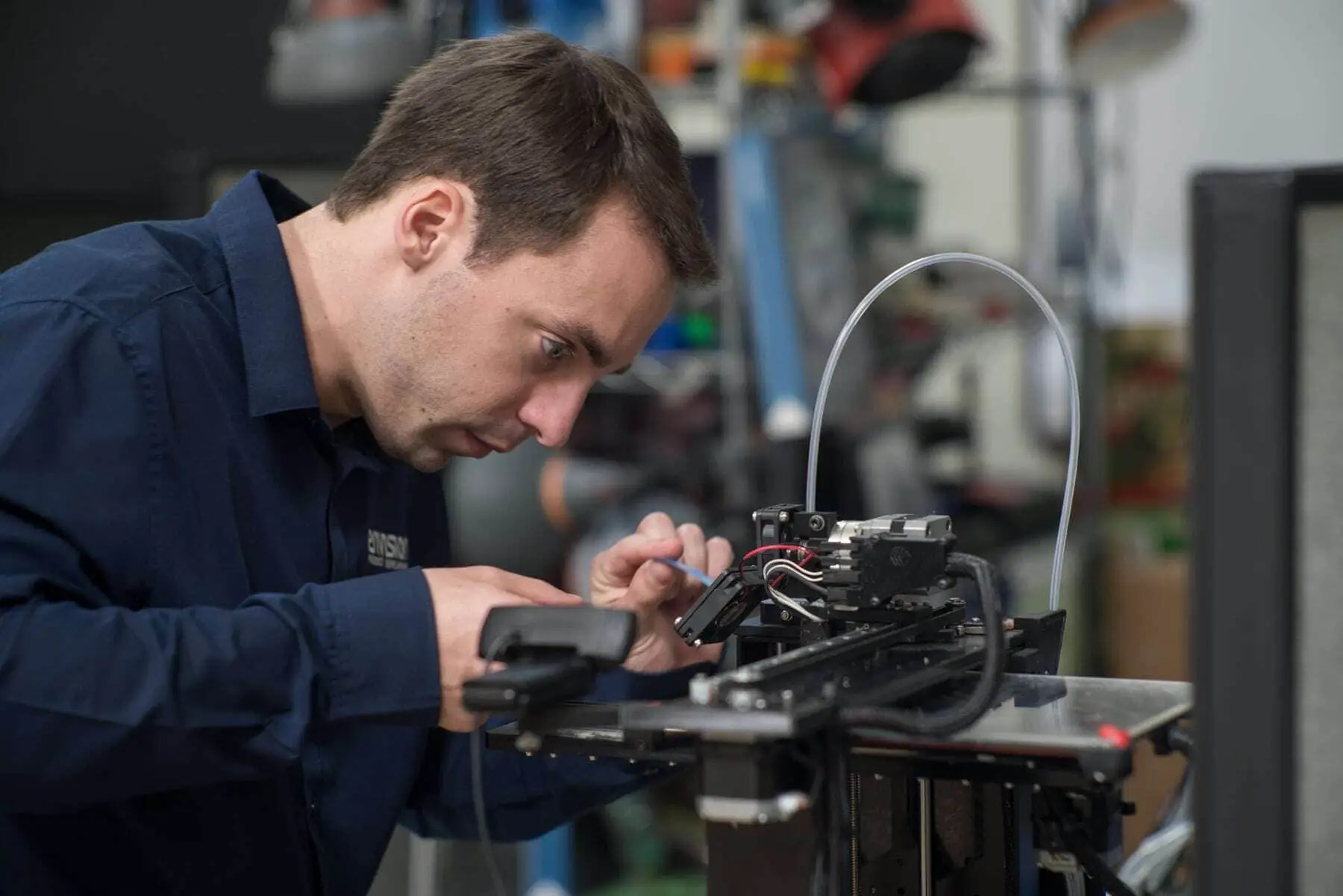 Garrett Smith working on 3D printer Envision - Services